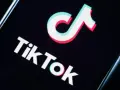 Logo TikToka na czarnym tle. Aplikacja zyskała popularność w 2018 roku, choć jej początki sięgają 2016.
