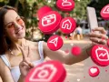 Uśmiechnięta dziewczyna robi selfie, otoczona ikonami mediów społecznościowych. Zastanawia się, followers co to znaczy dla jej popularności.