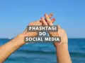 Dwie dłonie tworzą znak #. Tekst: #HASHTAGI DO SOCIAL MEDIA. Idealne gotowe hashtagi na wakacje!