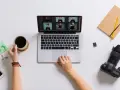 Praca blogera: przeglądanie zdjęć na laptopie, kawa, aparat i notatnik.