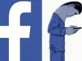 Logo FB obok postaci zgarbionej nad telefonem. Czy to już uzależnienie od Facebooka?