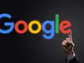 Palec wskazujący dotyka litery "e" w neonowym logo Google. To symbol tego, google co to jest - wyszukiwarka, która łączy nas ze światem.