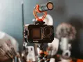 Kamera sportowa z mikrofonem na statywie, gotowa do nagrywania. Idealny sprzęt, by zacząć tworzyć własny vlog i dzielić się swoimi pasjami.