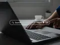 Osoba wpisuje zapytanie w wyszukiwarkę na laptopie, szukając najpopularniejszych wyszukiwarek internetowych w Polsce.