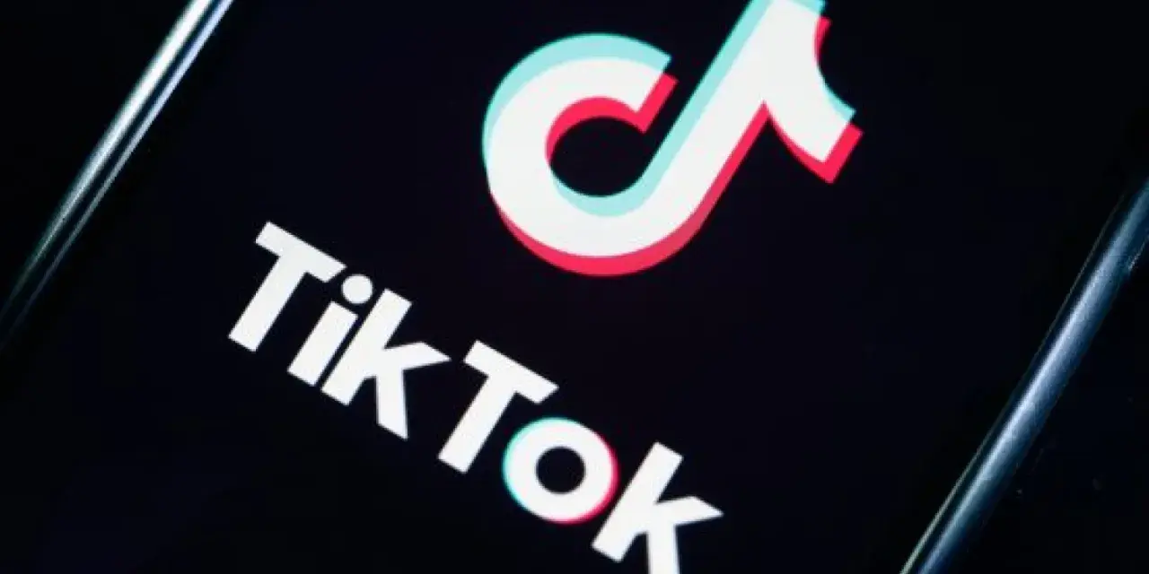 Logo TikToka na czarnym tle. Aplikacja zyskała popularność w 2018 roku, choć jej początki sięgają 2016.