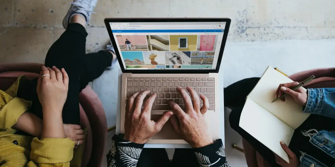 Zespół marketingu realizuje zadania: ktoś pisze na laptopie, ktoś notuje w zeszycie, tworząc kreatywną kampanię.