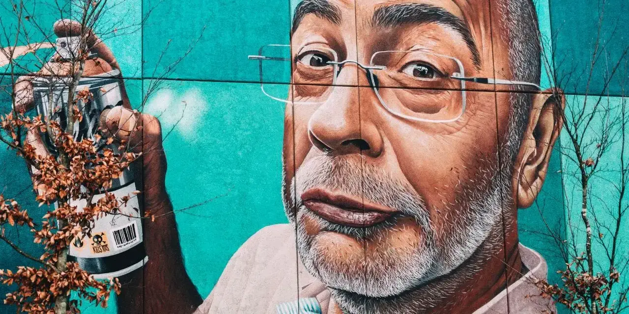 Mural przedstawiający mężczyznę z wąsami i okularami, trzymającego puszkę farby. To przykład odważnego guerrilla marketing.