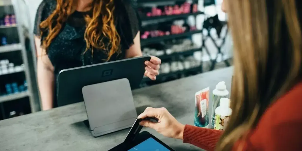 Klientka płaci kartą w sklepie, co jest przykładem, jak działa omnichannel – płynne połączenie różnych kanałów sprzedaży.