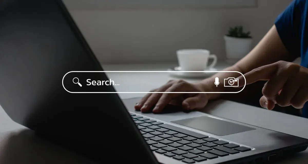 Osoba wpisuje zapytanie w wyszukiwarkę na laptopie, szukając najpopularniejszych wyszukiwarek internetowych w Polsce.