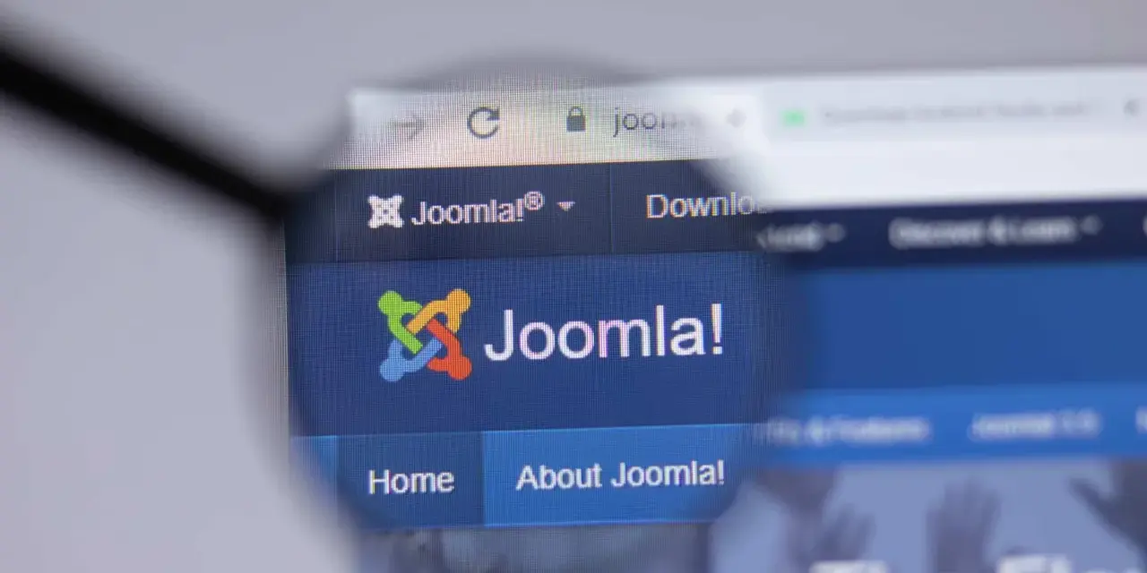 Lupa powiększa logo i nazwę Joomla!, systemu zarządzania treścią. Dowiedz się, joomla co to jest i jak działa.