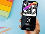 Dłoń trzyma smartfon z aplikacją Threads, która pozwala dzielić się pomysłami i trendami.