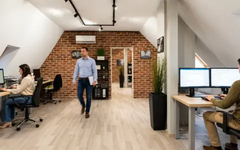 Pracownicy biura z ceglaną ścianą, tworzący strategię marketing internetowy definicja.