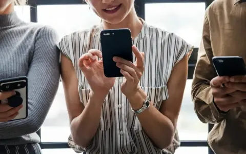 Trzy osoby trzymają telefony, sprawdzając powiadomienia.