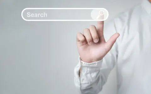 Palec wskazujący dotyka paska wyszukiwania, symbolizując wyszukiwanie informacji i dane strukturalne Google.
