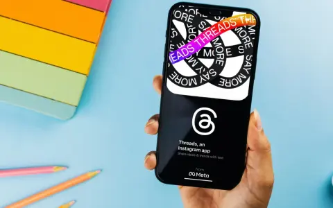 Dłoń trzyma smartfon z aplikacją Threads, która pozwala dzielić się pomysłami i trendami.
