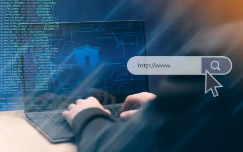 Osoba wpisuje adres strony w przeglądarce, symbolizując bezpieczeństwo w internecie. SSL co to jest? To szyfrowanie połączenia.