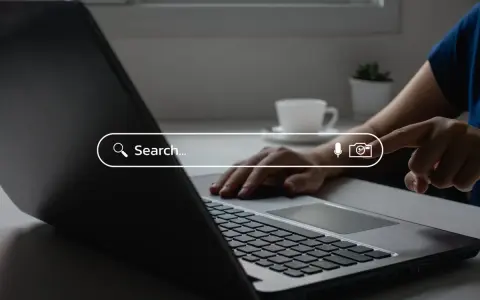 Osoba wpisuje zapytanie w wyszukiwarkę na laptopie, szukając najpopularniejszych wyszukiwarek internetowych w Polsce.