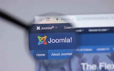 Lupa powiększa logo i nazwę Joomla!, systemu zarządzania treścią. Dowiedz się, joomla co to jest i jak działa.