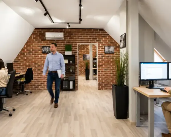 Pracownicy biura z ceglaną ścianą, tworzący strategię marketing internetowy definicja.