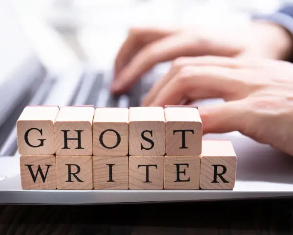 Drewniane klocki z literami tworzą napis "GHOST WRITER". Kto to taki? To pisarz, który tworzy teksty dla kogoś innego.