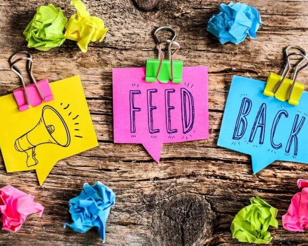 Kolorowe karteczki z napisem "FEED BACK" i rysunkiem megafonu. Świetne feedback przykłady!