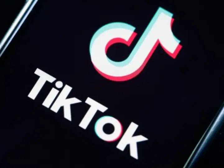 Logo TikToka na czarnym tle. Aplikacja zyskała popularność w 2018 roku, choć jej początki sięgają 2016.