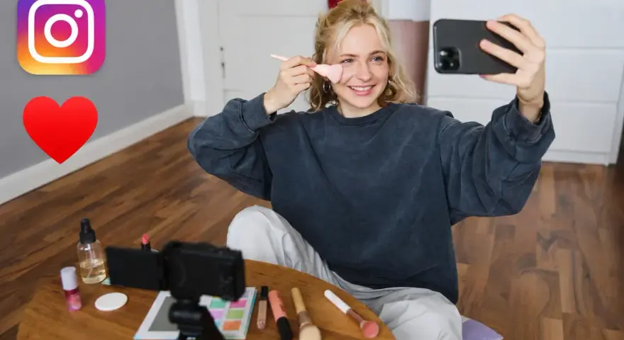 Dziewczyna nagrywa tutorial makijażowy na Insta. Na stole kosmetyki i kamera. #hasztagimakeup #beautyvlogger