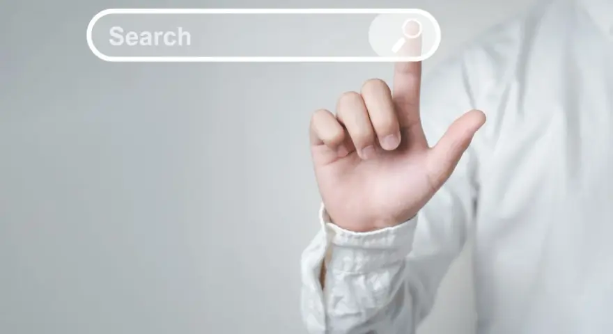 Palec wskazujący dotyka paska wyszukiwania, symbolizując wyszukiwanie informacji i dane strukturalne Google.