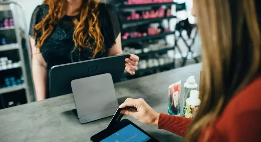 Klientka płaci kartą w sklepie, co jest przykładem, jak działa omnichannel – płynne połączenie różnych kanałów sprzedaży.