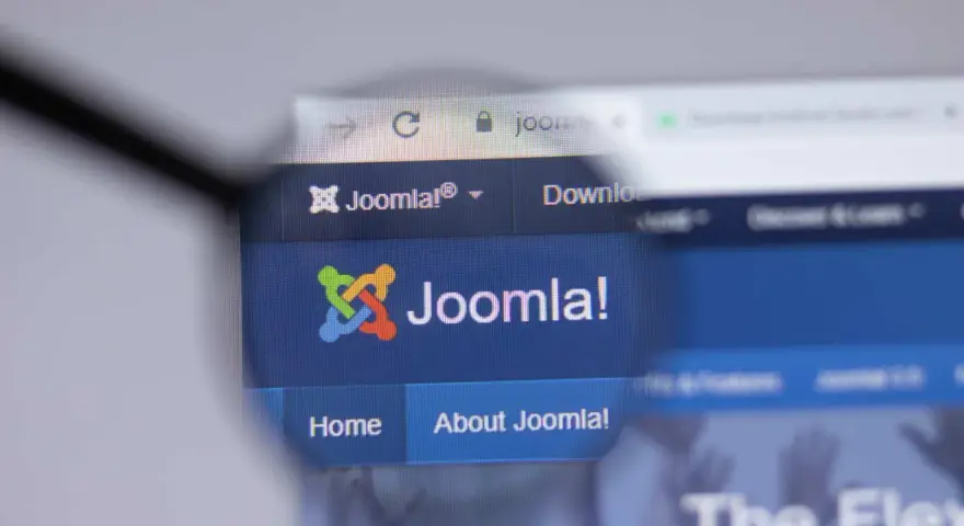 Lupa powiększa logo i nazwę Joomla!, systemu zarządzania treścią. Dowiedz się, joomla co to jest i jak działa.