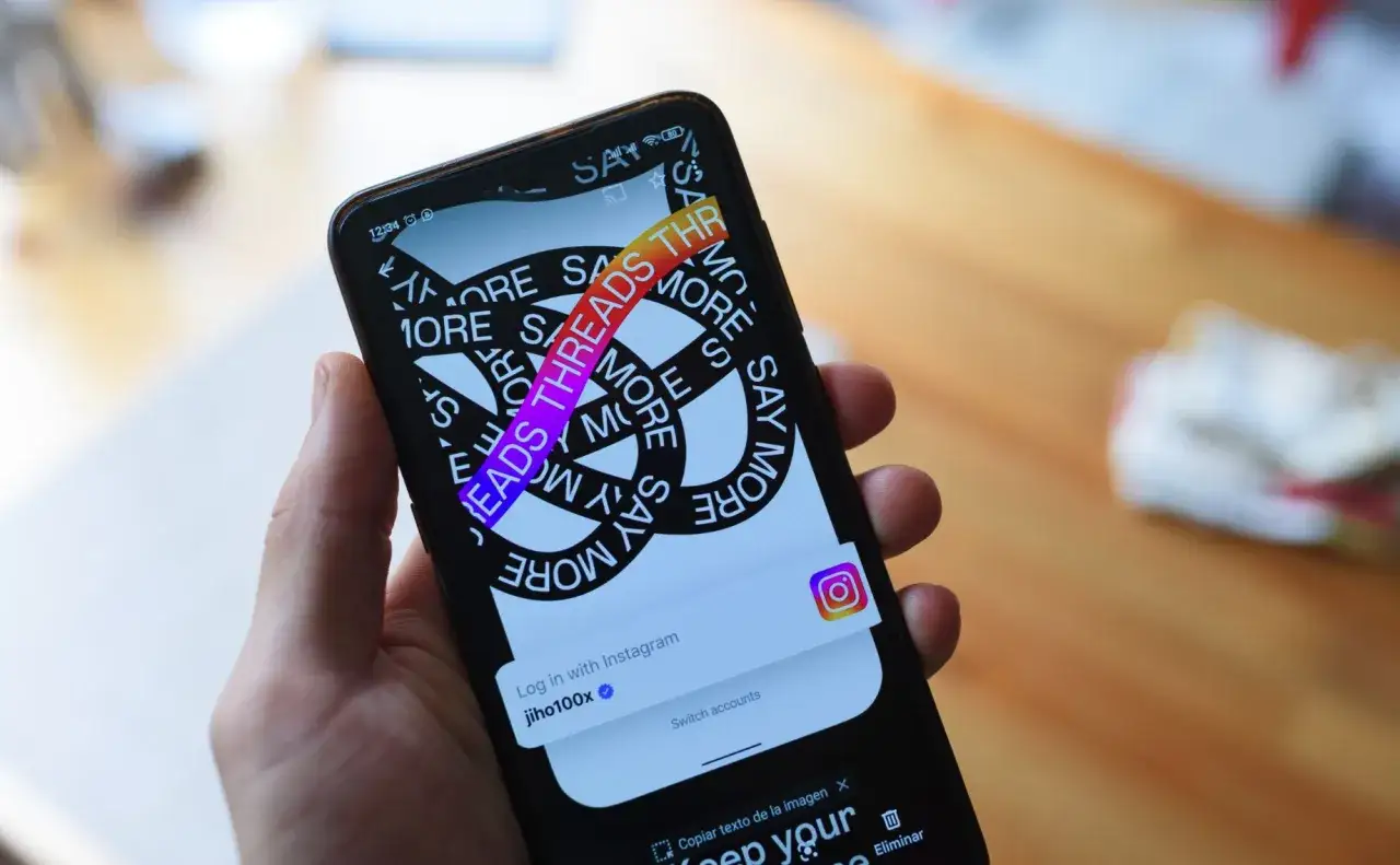 Telefon wyświetla ekran logowania do aplikacji Threads, która pozwala na