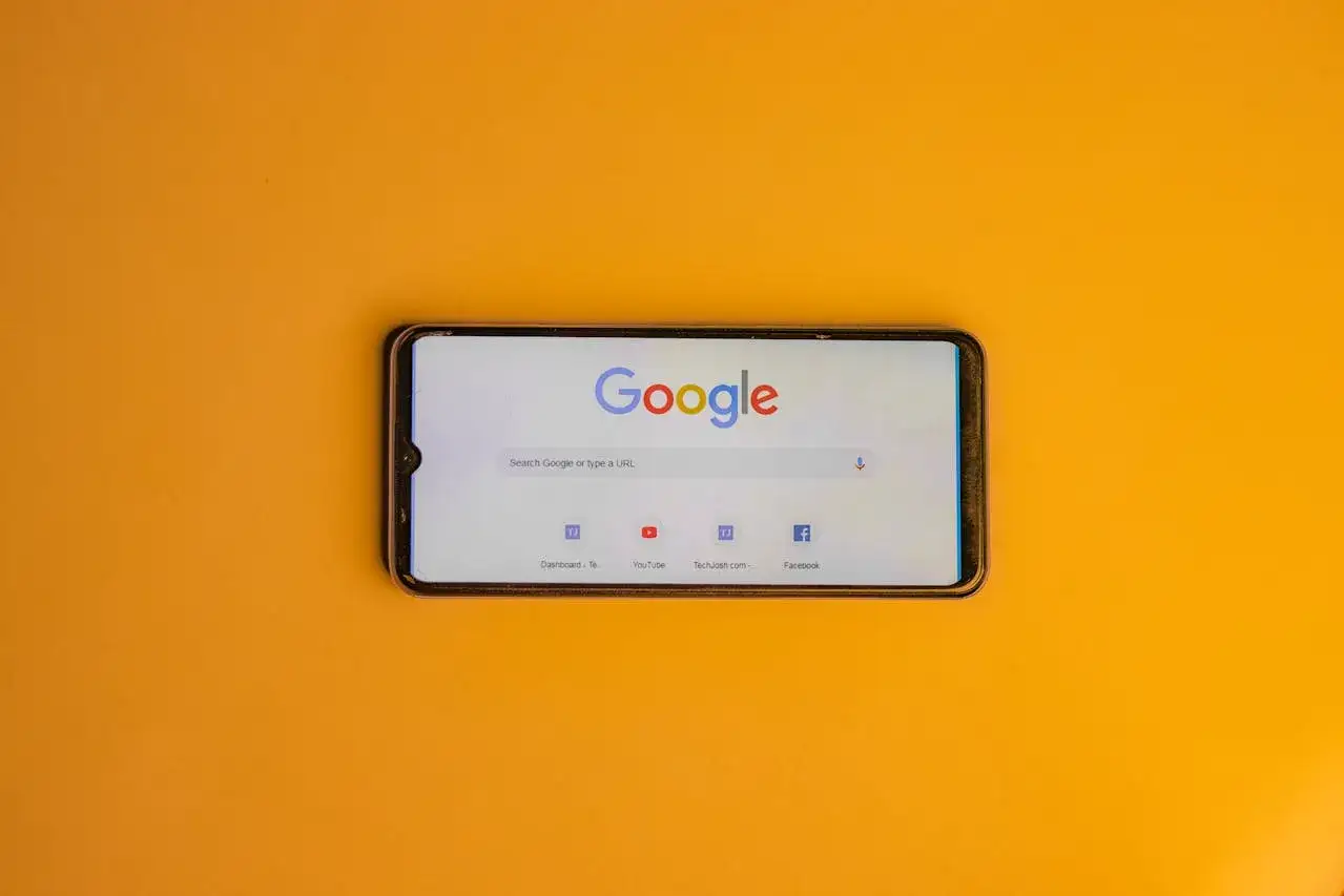 Telefon z otwartą wyszukiwarką Google. Uważaj na oszust&oacute;w podszywających się pod wizyt&oacute;wkę Google.