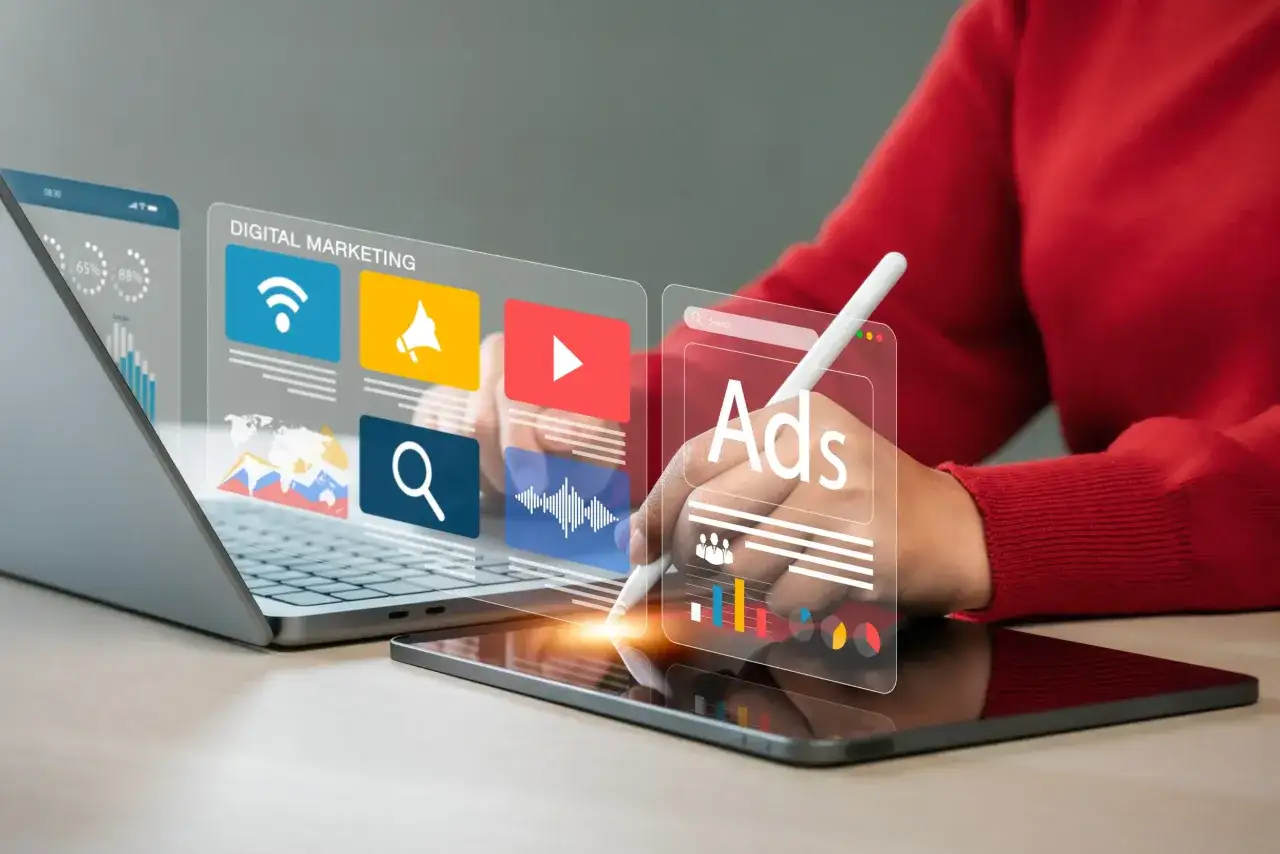 Osoba planuje jak wypromować bloga, korzystając z narzędzi digital marketingu na tablecie i laptopie.
