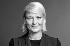 Uśmiechnięta polska influencerka o blond włosach, w czarnym ubraniu, patrzy w obiektyw.